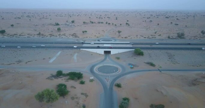 Busy Highway With Tunnel And Roundabout At The Ras Al Khaima Desert In UAE - aerial shot