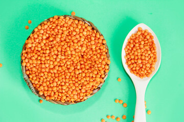 small grains of natural red lentils on a green background