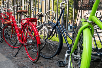 Colourful bicycles parked by railings in Copenhagen, Denmark