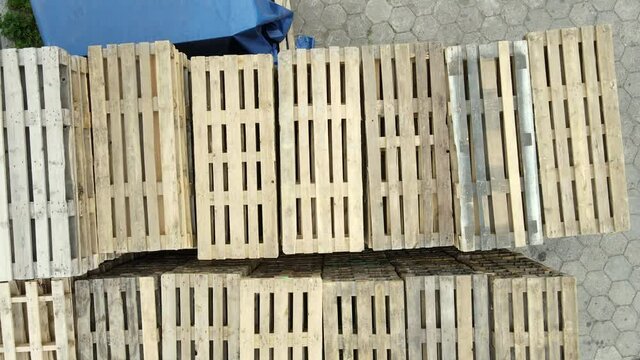Top down shot of wooden pallets stack in the warehouse. Pile of different type of pallets in a transporting business. Stack of wooden pallets.