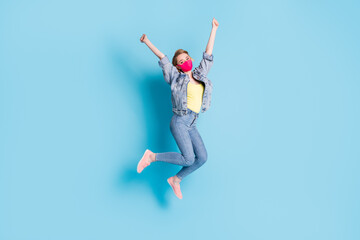 Fototapeta na wymiar Full body photo of pretty lady quarantine finished rejoicing outdoors jump high street walk good mood spread arms fists up wear face mask blazer jeans shoes isolated blue color background