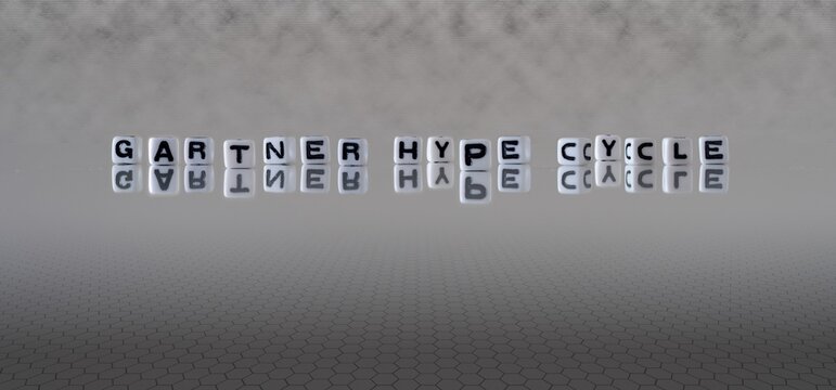 gartner hype cycle concept represented by black and white letter cubes on a grey horizon background stretching to infinity