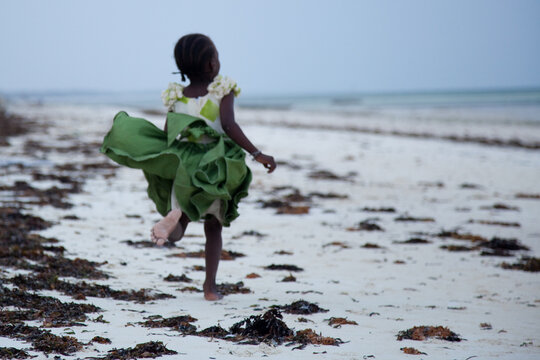 african girl running on the beach in Zansibar