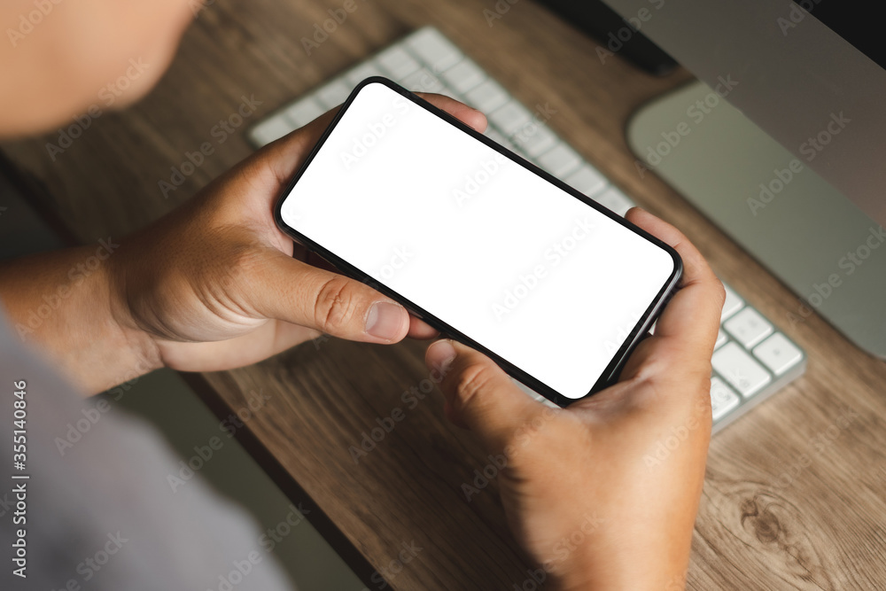 Poster top view mockup image hand using a smartphone man holding cell phone with blank screen