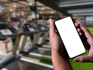 Young man Hand holding smartphone in gym to fitness phone fitness exercise concept.