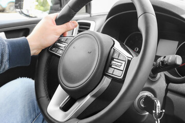 Media control buttons on the steering wheel in black leather with computer monitor, modern car...