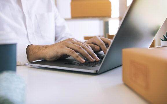Entrepreneurs are working on taking orders of customers products by typing information tpying keyboard laptop computer in office room.