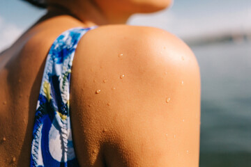 shoulder with water drops close up, drops of sea on the skin. Summer vacation. Enjoying summer holiday on the sea. High quality photo