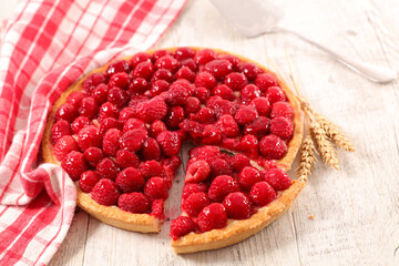 raspberry tart with cream on wood background