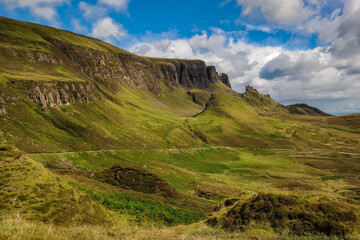 Red car pass through at the foot of Quiraing, Sunny day at Quiraing, Isle of Skye