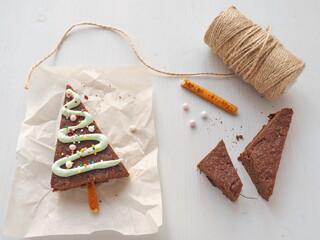 Assembling and packaging of triangle brownie dessert. Chocolate cake as Christmas tree. Selective focus. Top view.