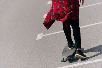 Fototapeta premium Beautiful young hipster woman with longboard on the road in the city in sunny weather