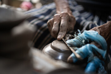 male potter is making a vase from clay, selective focus.