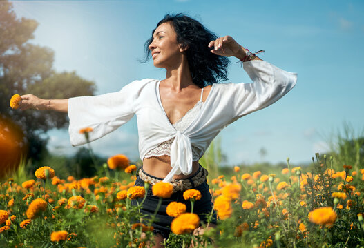 Woman Dancing In Orange Flowers Field And Smiling