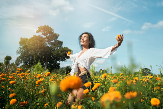 Woman Dancing In Orange Flowers Field And Smiling
