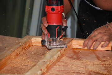 Carpenter working on woodworking machines in carpentry shop