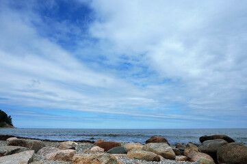 Rocks on the seashore. The sandy shore of the sea. Waves on the Baltic Sea.
