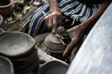 male potter is making a vase from clay, selective focus.