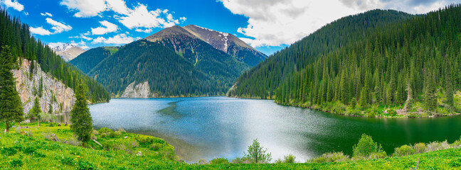 Panorama of amazing beautiful mountain lake surrounded by coniferous forest