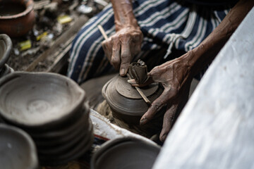 male potter is making a vase from clay, selective focus.