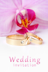 Close-up of wedding rings on background of orchid