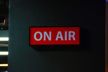 On Air sign icon glowing on the wooden wall of sound recording studios