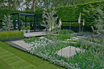 A modern Cool Scandinavian stylish  garden design with flowers and shrubs