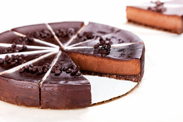 Chocolate cheesecake with chocolate glaze on white background.
