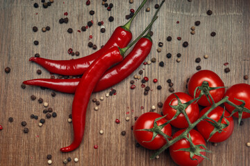 Red ripe fruits of chili pepper and cherry tomato with peppercorns