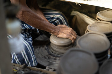 male potter is making a vase from clay, selective focus.