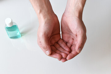 Man's hands isolated on white and hand sanitizer in the background, healthcare background, covid-19 concept