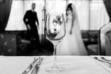 In the foreground is an empty glass of wine and cutlery.