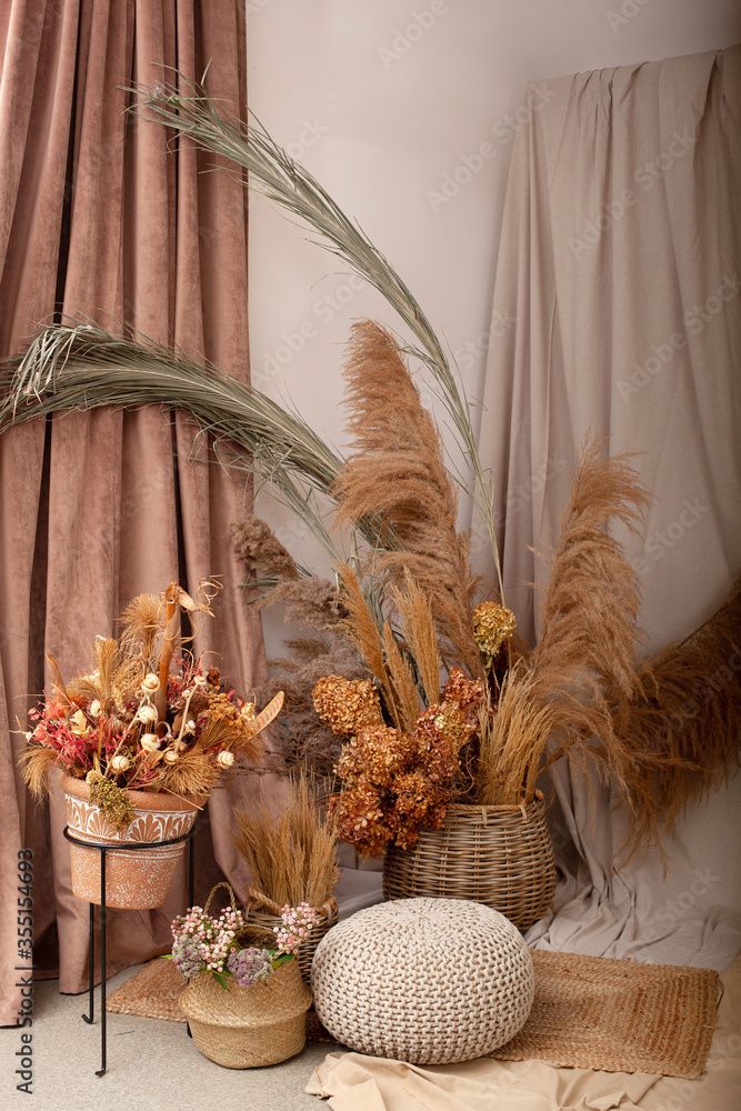 Canvas Prints Home cozy interior of room in brown tones with dried flowers, pampas grass and branches in basket. Scandinavian design. Rustic. Boho. Dry flowers in pot in elegant room interior with natural accents