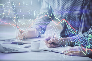 Multi exposure of forex chart with man working on computer on background. Concept of market...