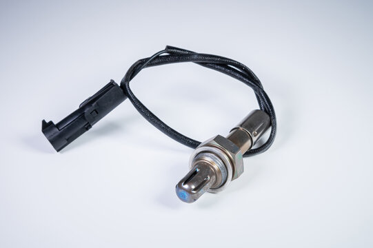 The oxygen sensor is a new lambda sensor. Spare parts on the car on a gray gradient background