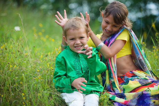 A lot of small children, boys and girls, dressed in the clothing culture of India.