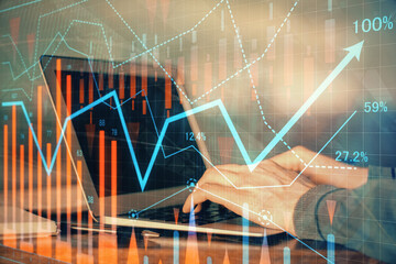 Double exposure of stock market graph with man working on laptop on background. Concept of...