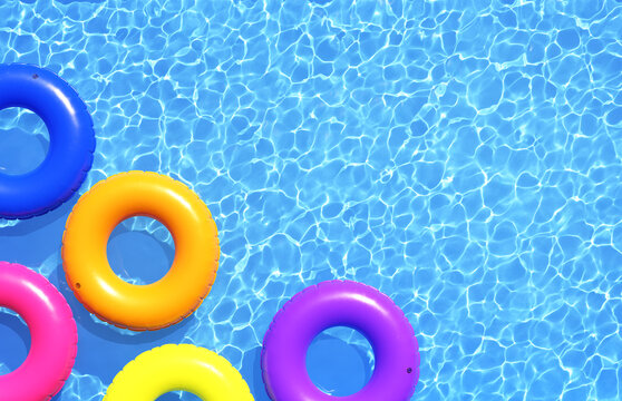 Top view of colorful swim rings on the blue water background. 