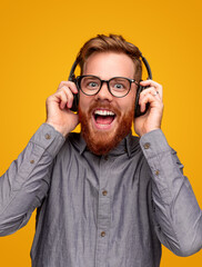 Excited young man with headphones enjoying music © kegfire