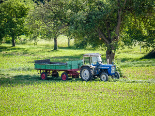 Traktor parkt mit Anh&auml;nger auf dem Feld