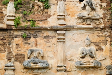 view of ancient buddha sculpture on brick wall of ruin temple, Wat Chet Yot or officially called Wat Photharam Maha Wihan in Chiang Mai City, northern of Thailand.