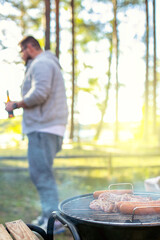 Man relaxing on the garden, preparing barbecue.