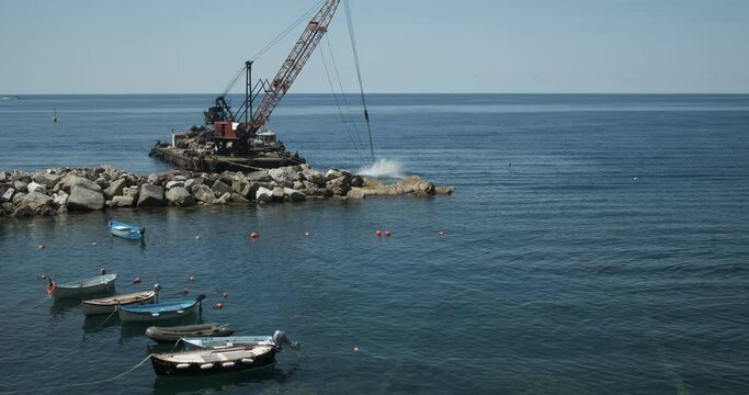 Barge with crane for dredging the seabed. Port of Riomaggiore. royalty free stock photo.