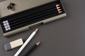 Pencils and eraser on a grey background