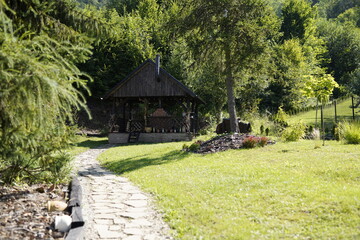 Fototapeta premium Altes Landhaus, Berhaus, Berghütte aus Holz und Stroh angebrannt, Grill, Feuerstelle, Wald, Bergurlaub, Land