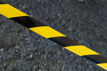 Black and yellow striped tapes on dark back. Restricted area border. Passage is forbidden.