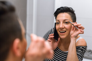 woman picking eyebrows in her bathroom