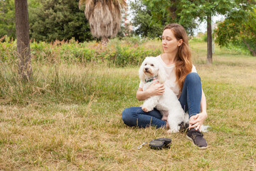 Fototapeta premium Beautiful young girl on a walk in the Park with her dog.