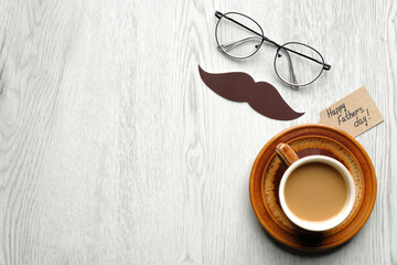 Happy Fathers Day concept. Happy Father's Day inscription, mustache, cup of coffee and male glasses on wooden table top view. Father's Day banner template.