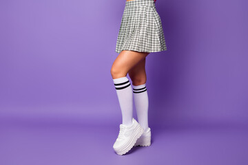 Cropped profile photo of lady showing cool stylish clothes outfit fit slim legs wear short plaid skirt long knee socks white shoes isolated pastel purple color background
